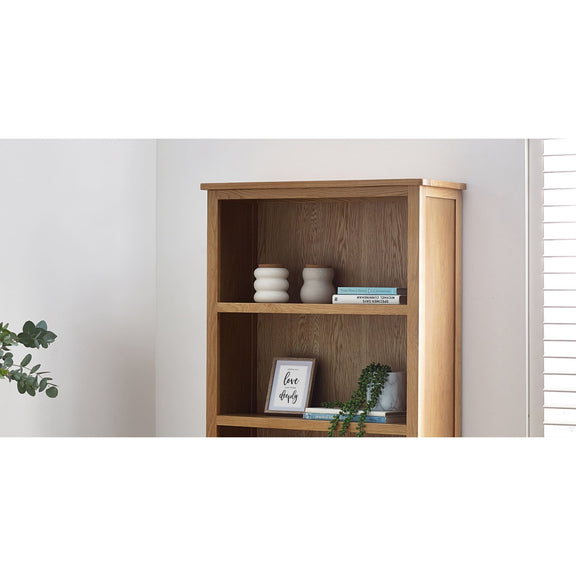 Wooden bookshelf with decorative items against a white wall