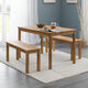 Wooden dining table with two benches in a room with a gray wall and white curtains.