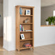 Wooden bookshelf with books and decor items against a white wall.