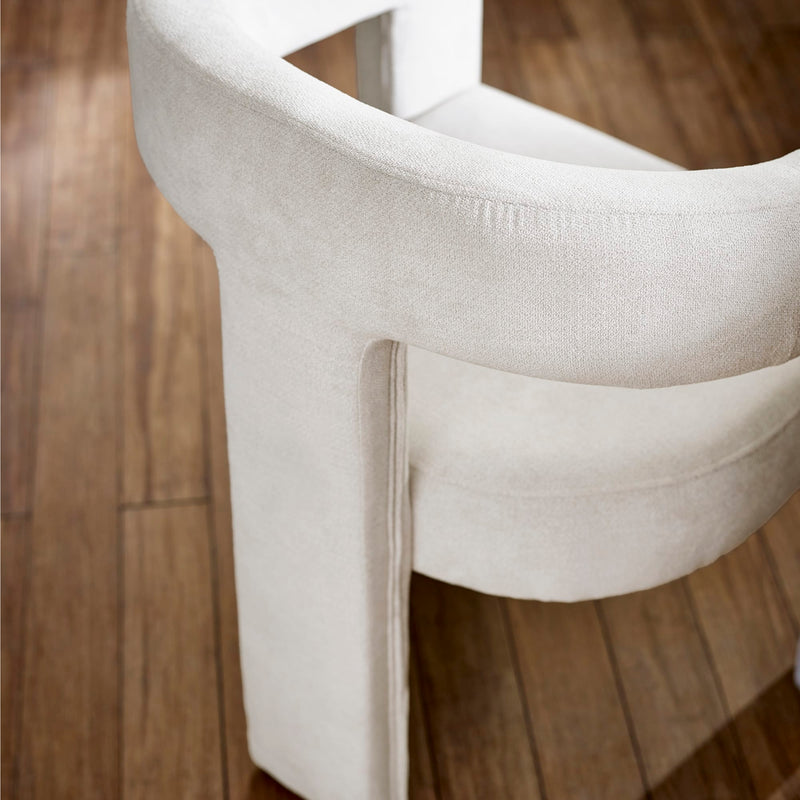 Close-up of a beige cushioned chair on a wooden floor