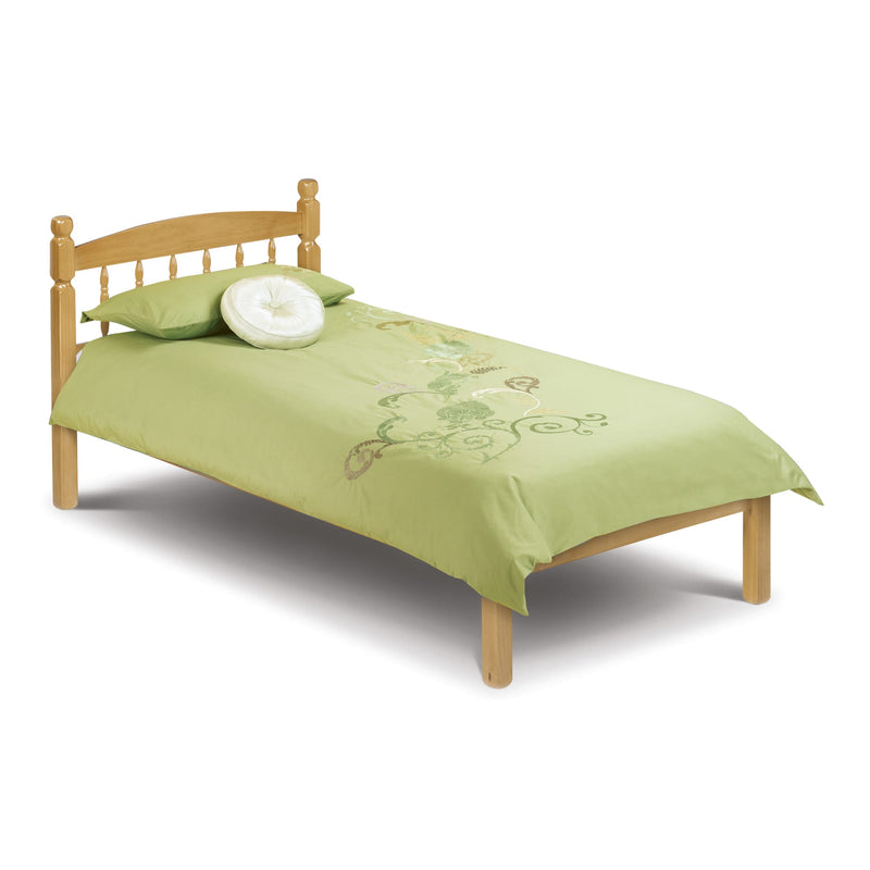 Single bed with green bedding and wooden headboard on a white background