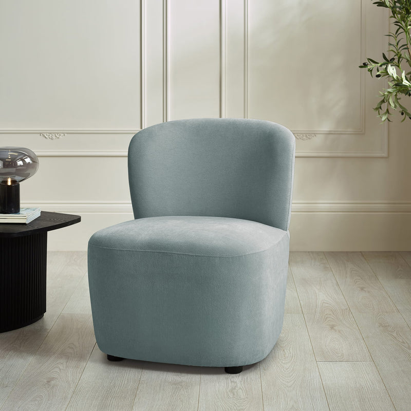 Blue armchair in a room with a light-colored wall and wooden floor.