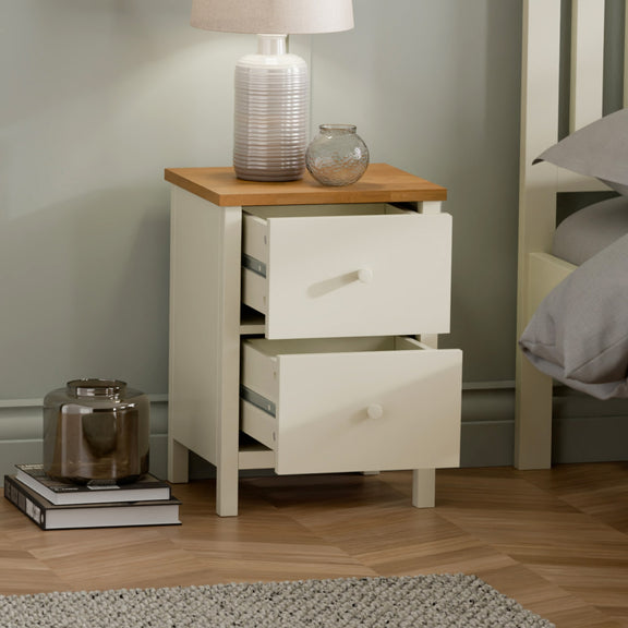 White nightstand with wooden top in a bedroom setting
