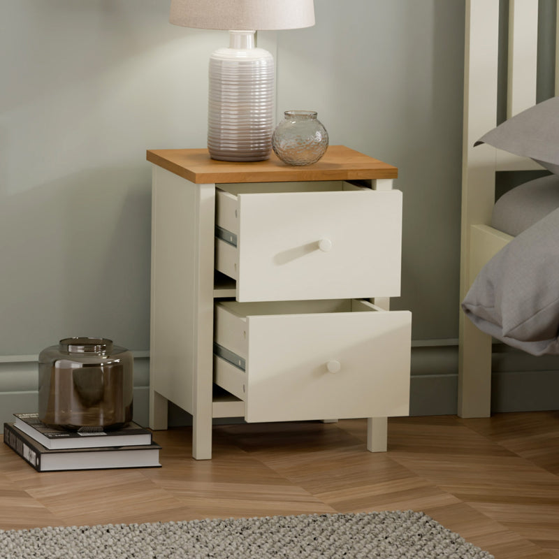 White nightstand with wooden top in a bedroom setting