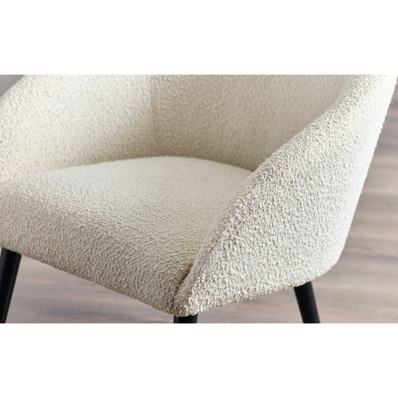 Close-up of a textured chair seat with a neutral color on a wooden floor.