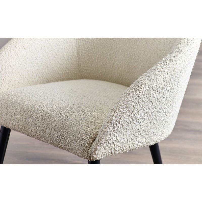 Close-up of a textured chair seat with a neutral color on a wooden floor.