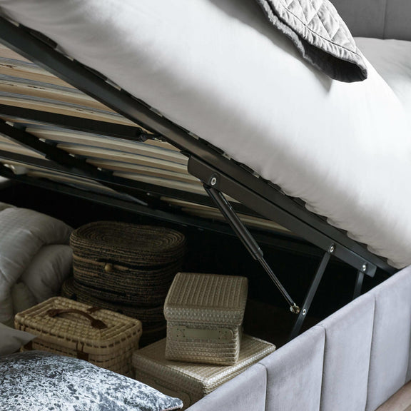 Underbed storage with wicker baskets and a mattress lift mechanism.
