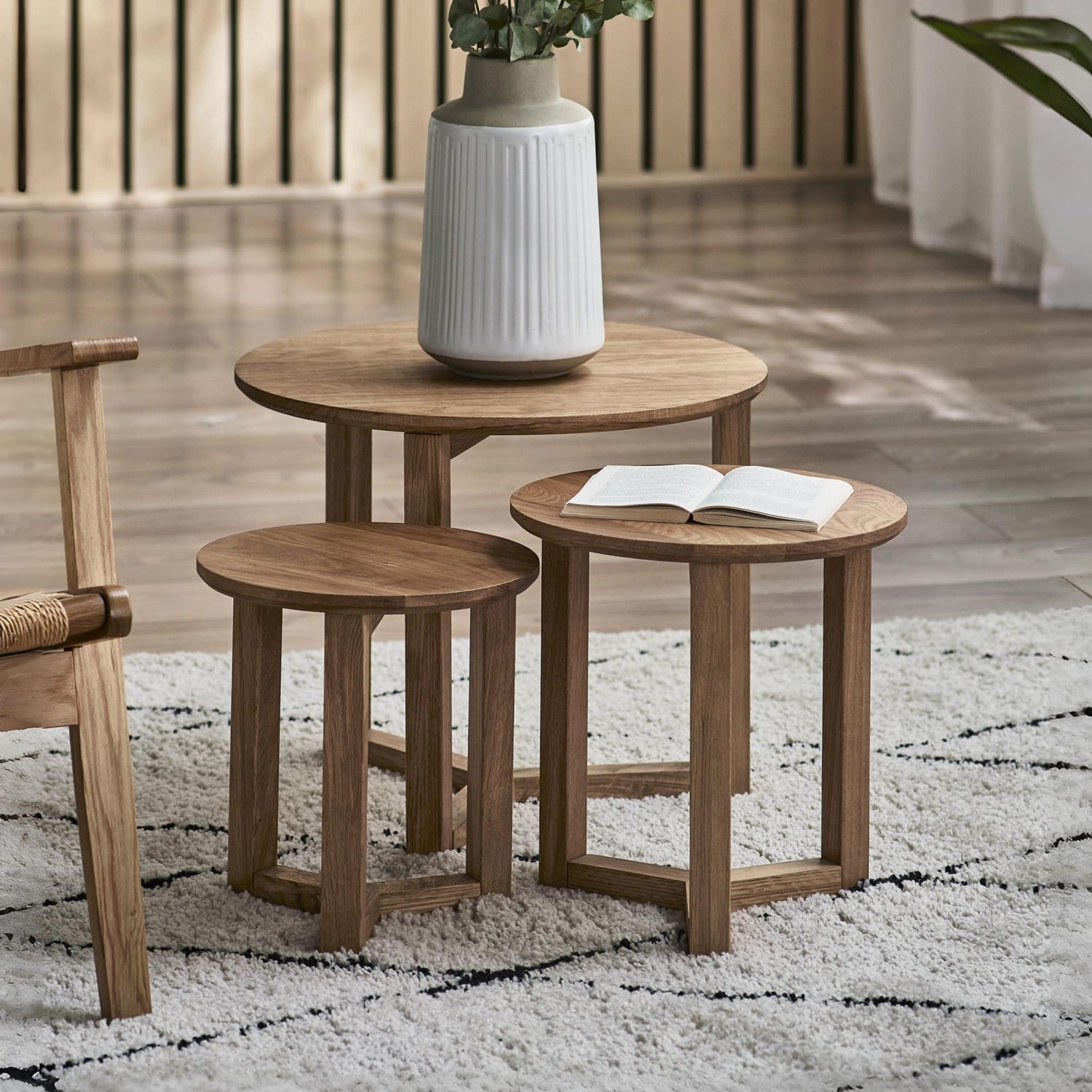 Set of wooden side tables with a vase and book on a rug
