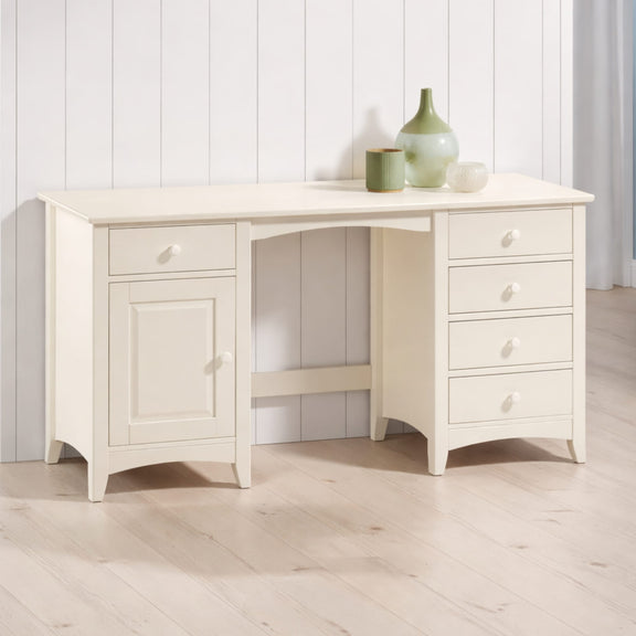 White wooden desk with drawers and a cabinet against a white paneled wall.