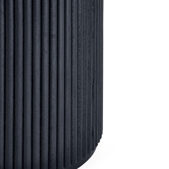 Close-up of a black tire with tread pattern on a white background