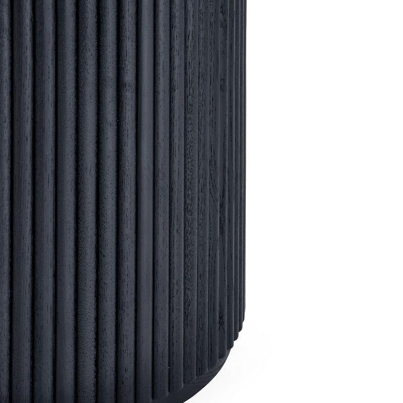 Close-up of a black tire with tread pattern on a white background