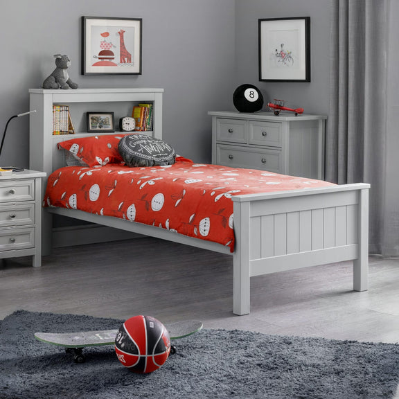 Children's bedroom with a white bed, red bedding, and sports-themed decor.