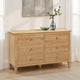 Wooden dresser with six drawers in a room setting.