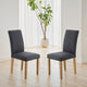 Two gray chairs on a wooden floor with a plant in the background
