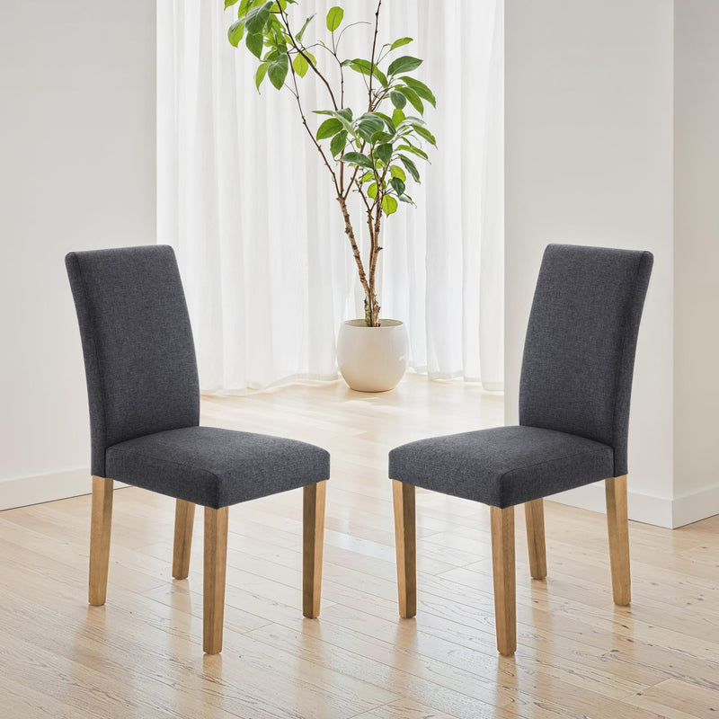 Two gray chairs on a wooden floor with a plant in the background