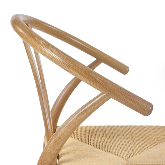 Close-up of a wooden chair with woven seat on a white background