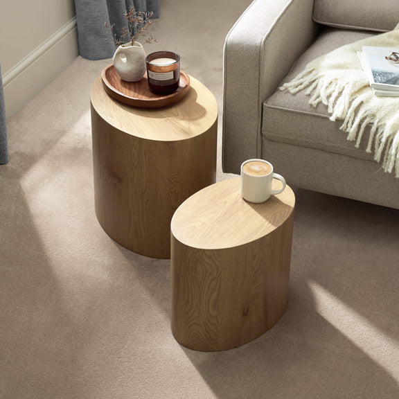 Two wooden side tables with decorative items in a living room setting.
