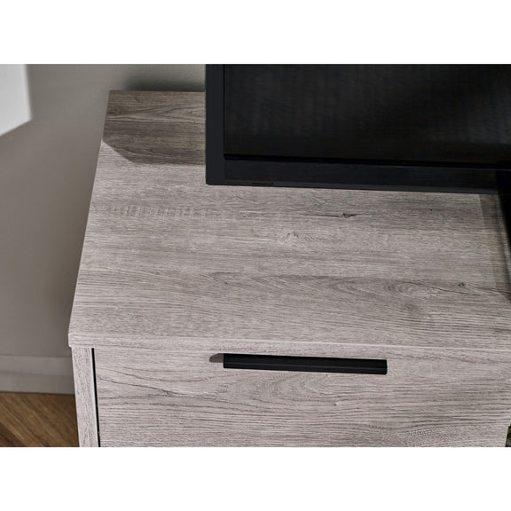 Wooden drawer with a black handle on a light wood floor.