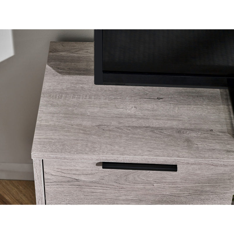 Wooden drawer with a black handle on a light wood floor.