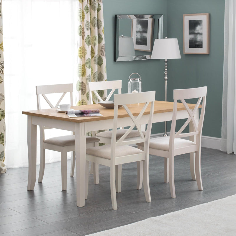 Dining room with a wooden table and white chairs against a green wall.