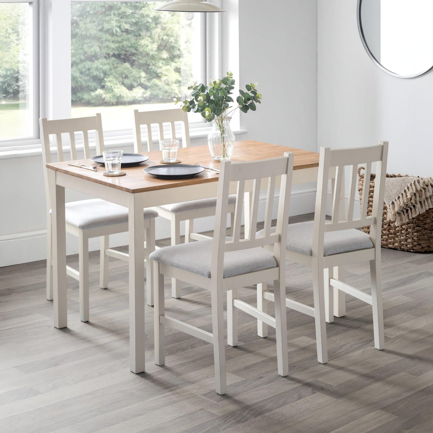 Dining table set with chairs in a room with large windows.