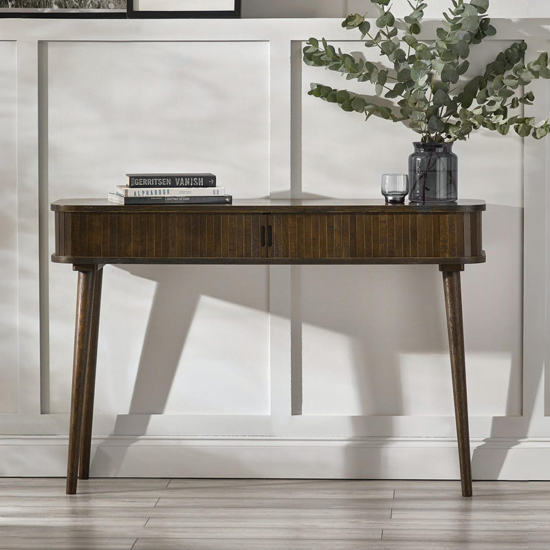Wooden console table with decorative items against a white wall