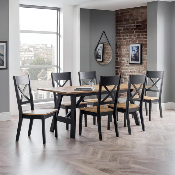 Dining room with a wooden table and chairs against a brick wall.