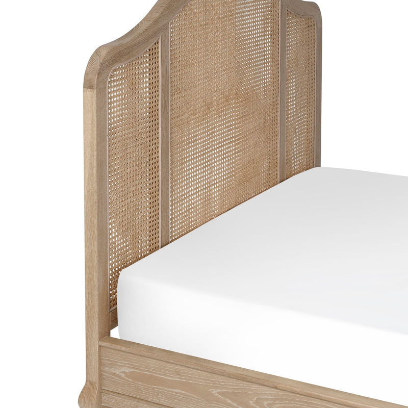 Wooden bed with wicker headboard and white mattress on a white background