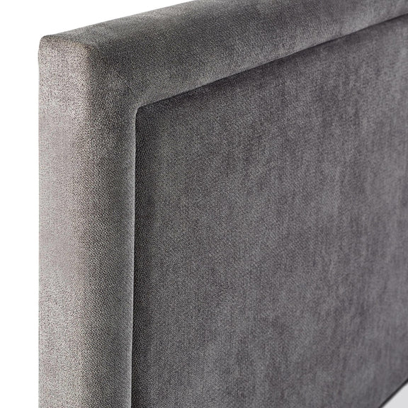 Gray upholstered headboard corner on a white background