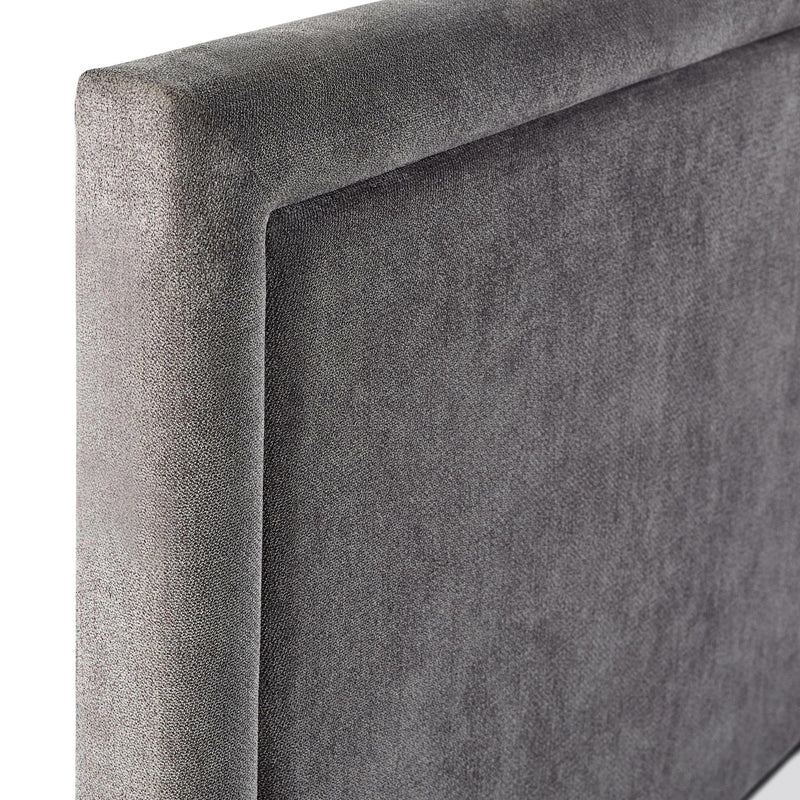 Gray upholstered headboard corner on a white background