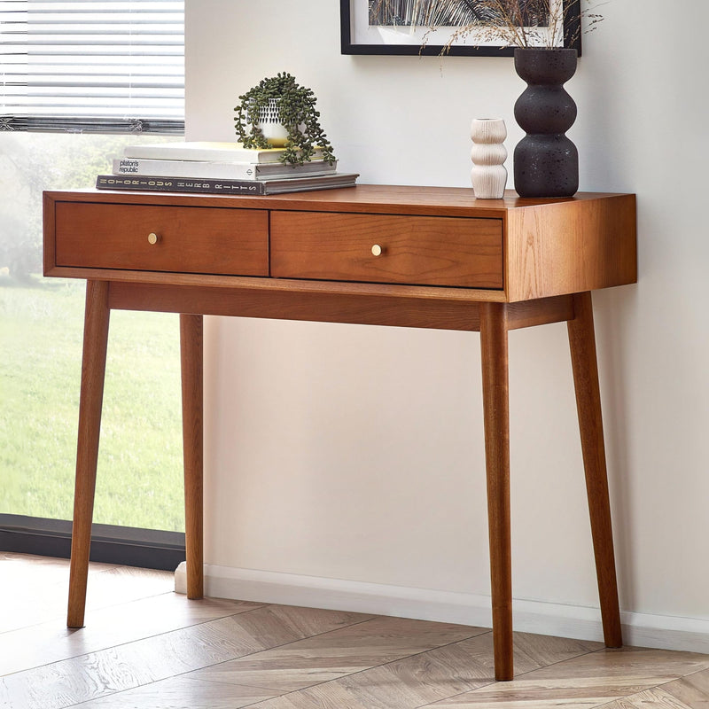 Wooden console table with two drawers in a room with a window and decor items.