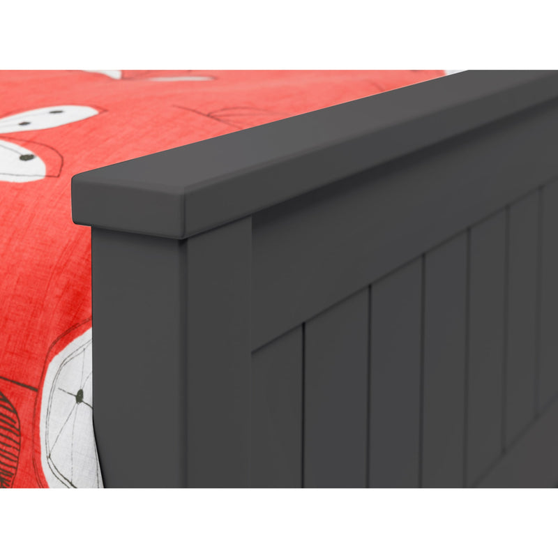 Dark gray wooden headboard against a red and white bedding background