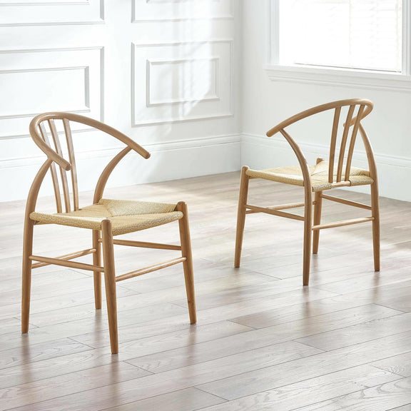Two wooden chairs with woven seats in a bright room with white walls and wooden floor.