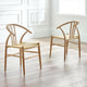 Two wooden chairs with woven seats in a bright room with white walls and wooden floor.