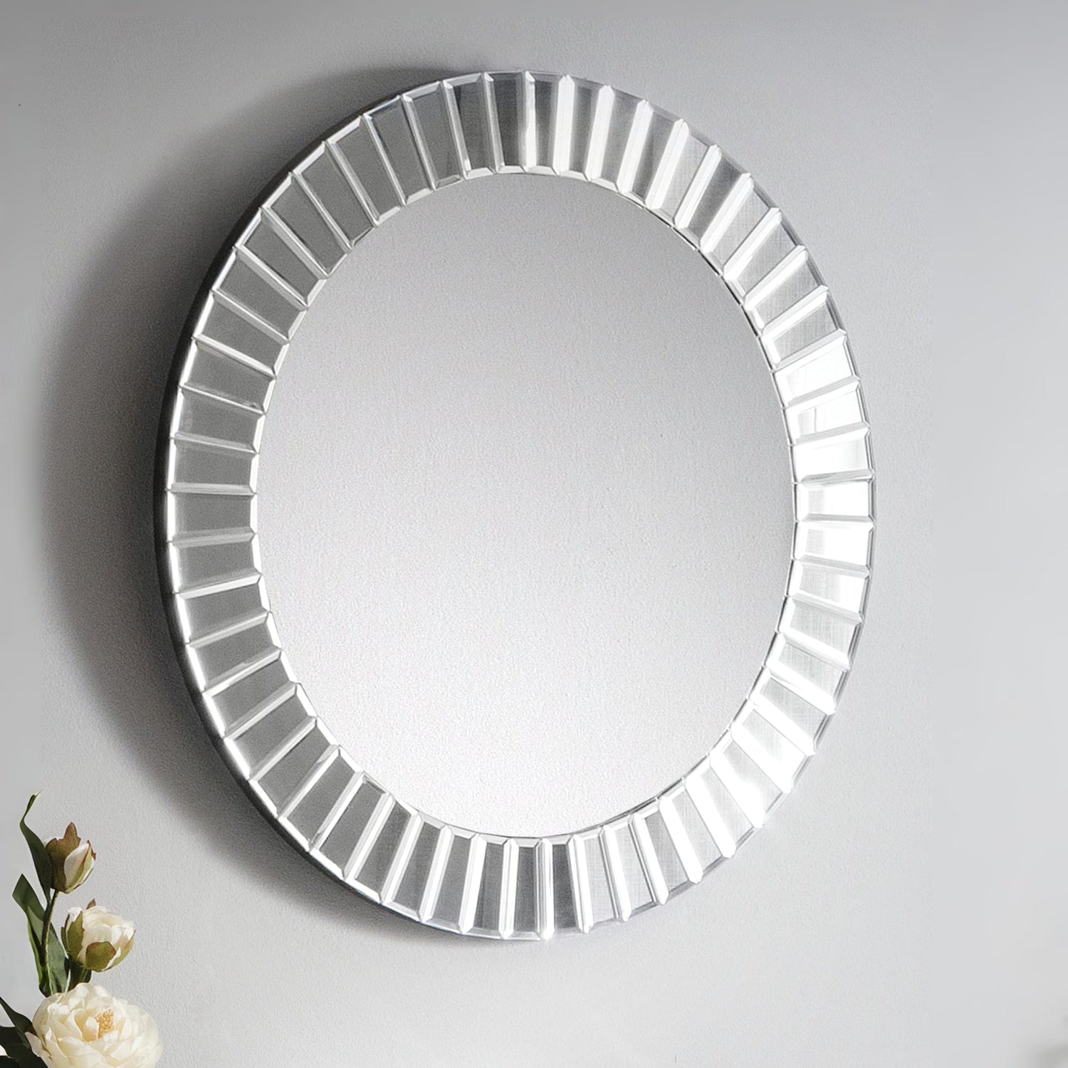 Round mirror with decorative frame on a gray background