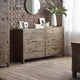 Wooden dresser against a brick wall with decorative items on top
