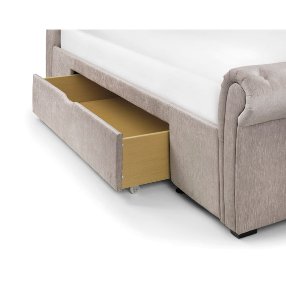 Gray upholstered bed with a gold drawer open on a white background