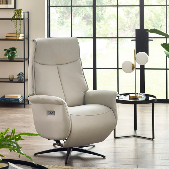 Beige recliner chair in a modern living room with large windows.