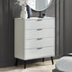 White dresser with black legs against a gray wall in a bedroom setting.