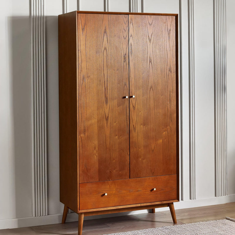 Wooden wardrobe with two doors and a drawer against a white wall.