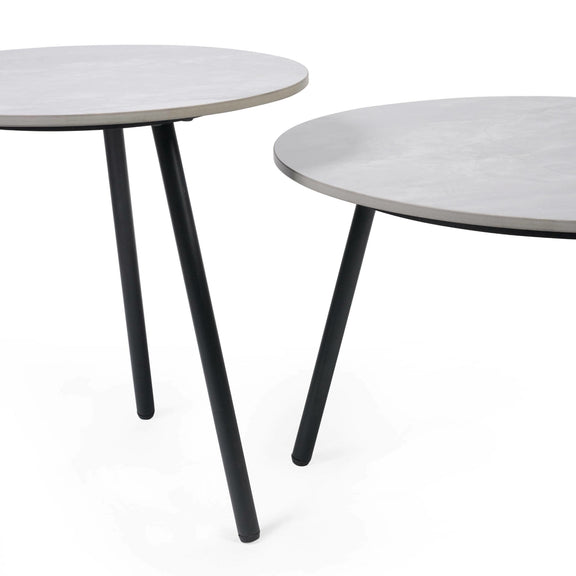 Two round tables with white tops and black legs on a white background