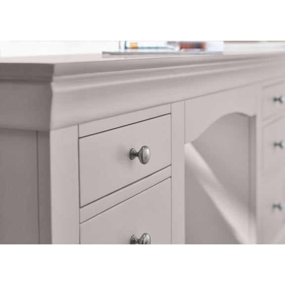 Gray dresser with a mirror and silver knobs on a white background