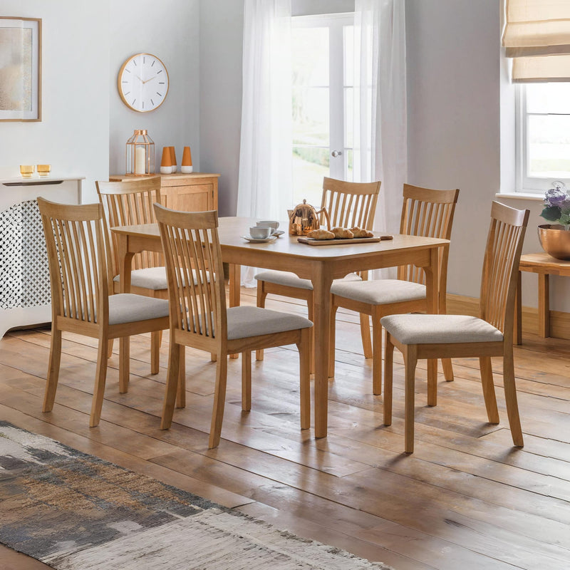 Dining room with wooden table and chairs on a wooden floor.