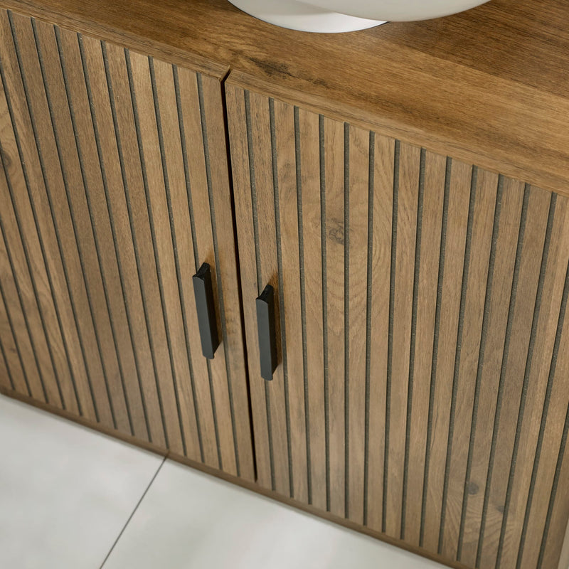 Wooden cabinet with slatted design and black handles on a white floor.