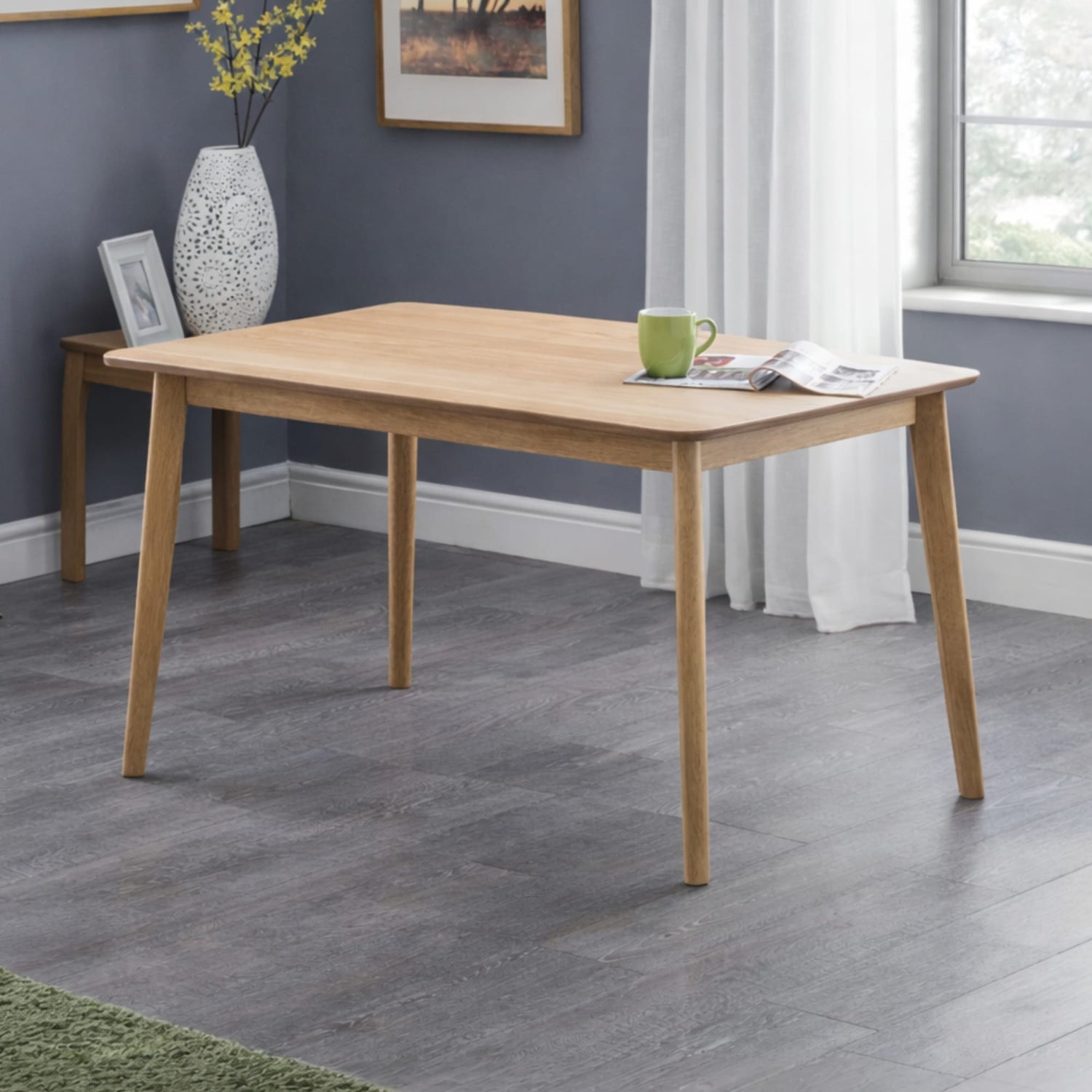 Wooden dining table in a room with gray flooring and a window.