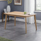 Wooden dining table in a room with gray flooring and a window.