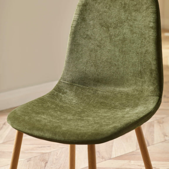 Green upholstered chair with wooden legs on a light wooden floor.