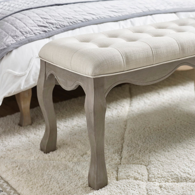 Decorative bench with tufted cushion on a carpeted floor