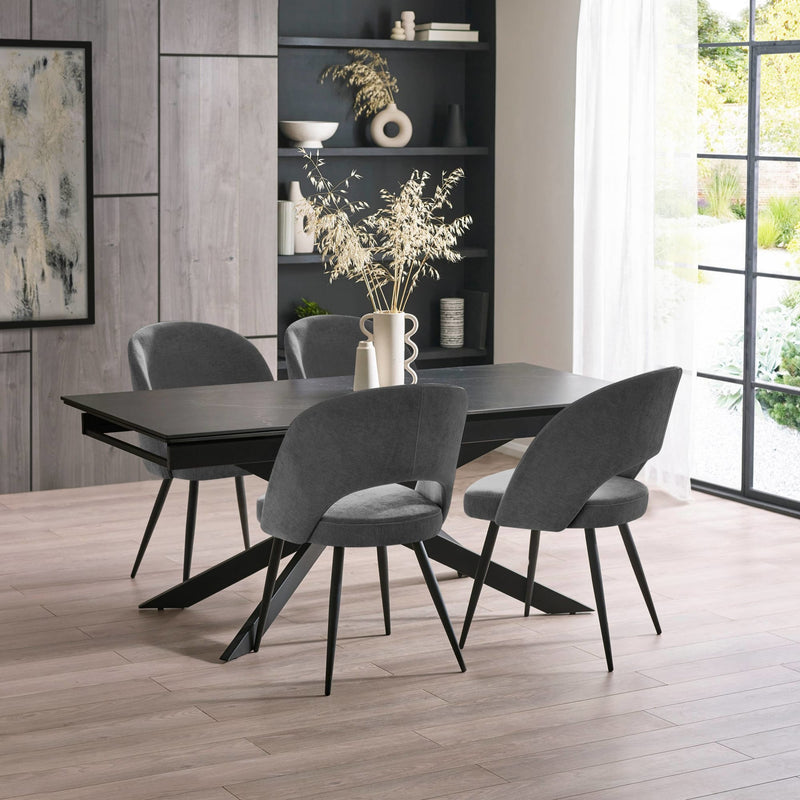Dining room with a black table and gray chairs in a modern interior setting.