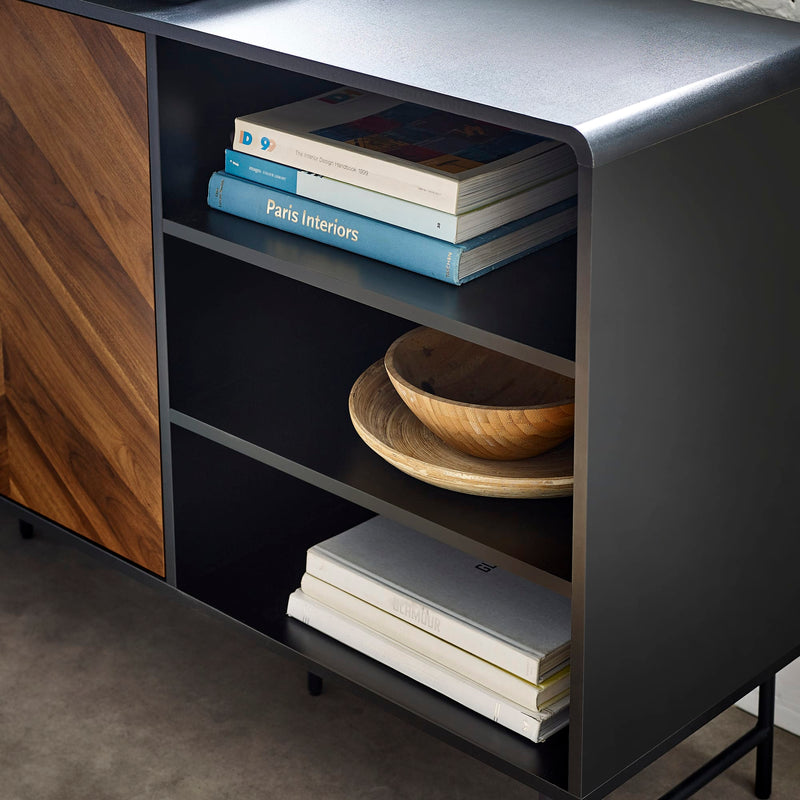 Dark wooden shelf with books and a bowl on a gray floor